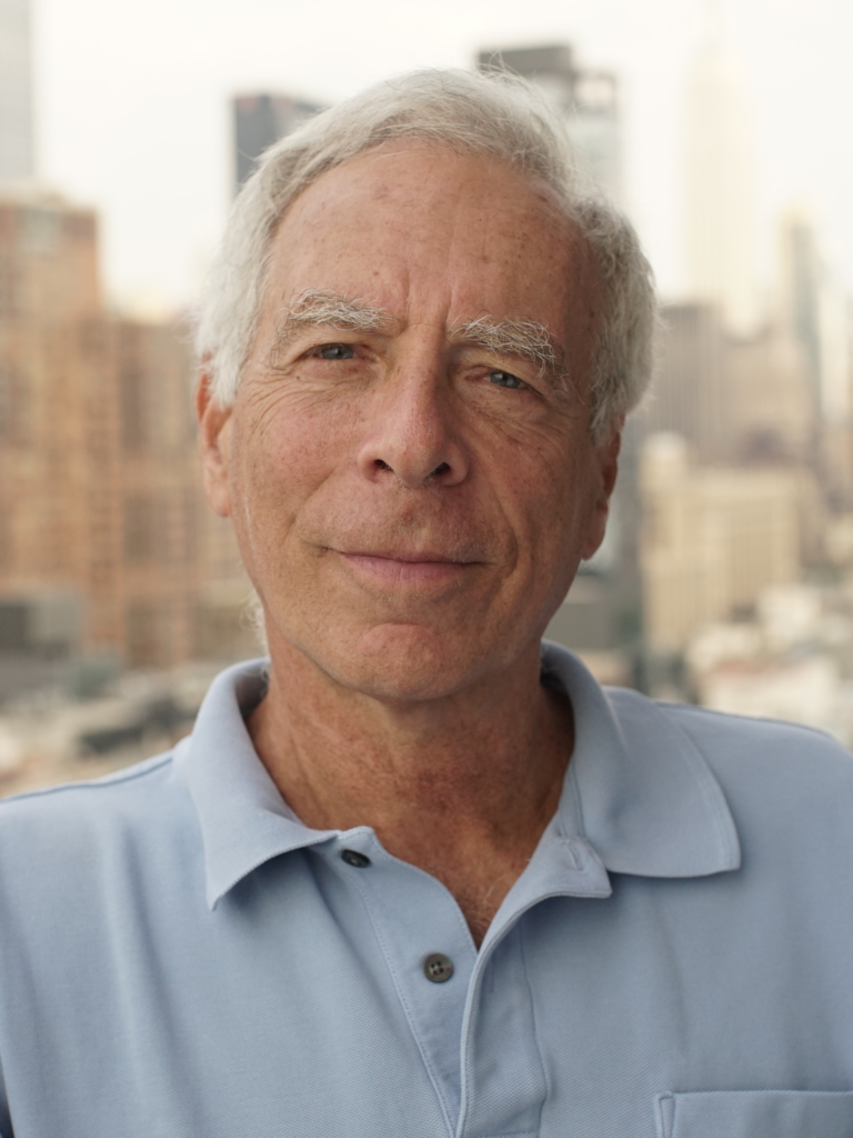 older white man in a blue polo looking at the camera