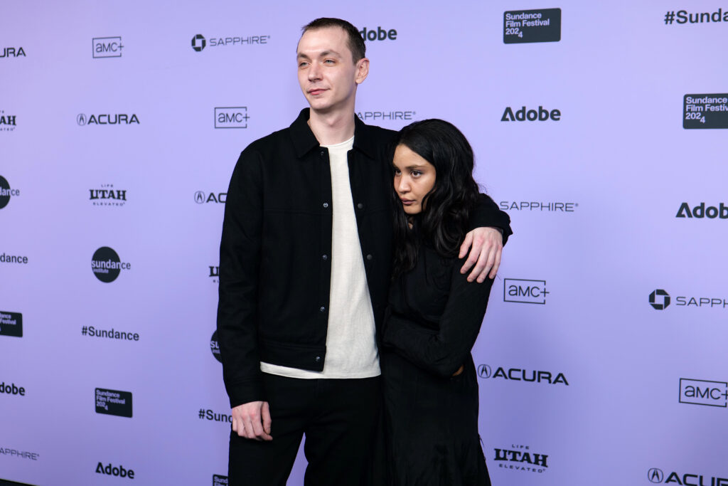 Yuri Pleskun and Kota Johan pose together in front of a white 2024 Sundance Film Festival backdrop.